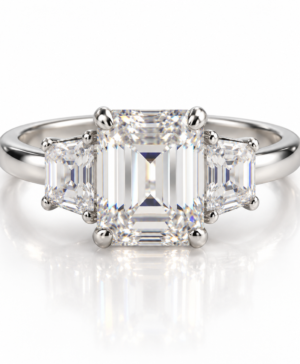 750/- White Band, White Setting Lab Grown Emerald Cut Centre With Step-Cut Trapezoid Each Side 3 Pcs Tdw: 5.00Ct Centre Emerald 4.00Ct 2 * Side Trapezoid Tdw: 1.00Ct E VVS